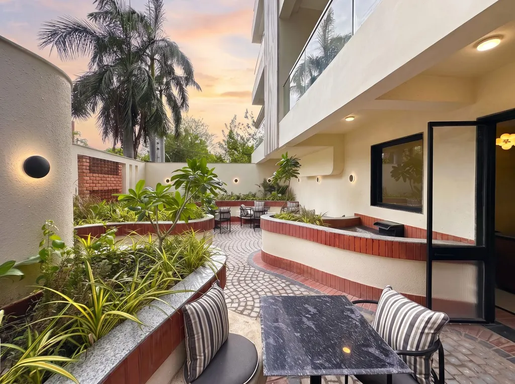 Courtyard at sunset with curved terracotta seating and palms